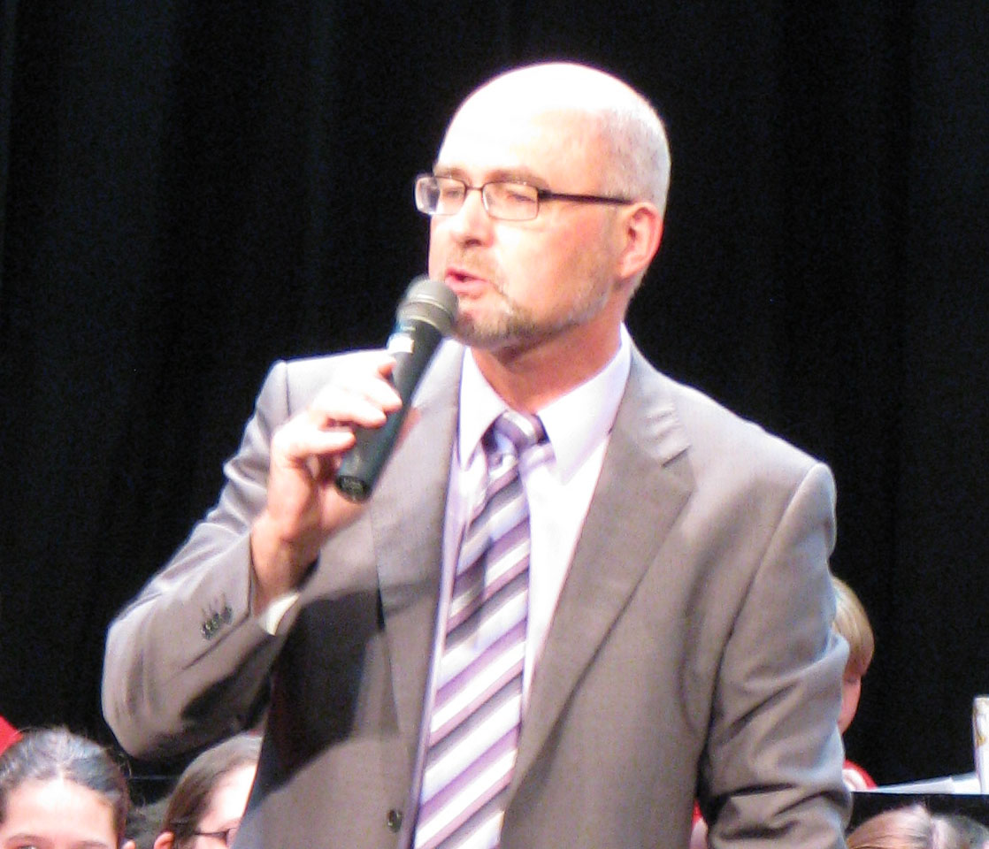 Photo of Bill Simon speaking at a concert